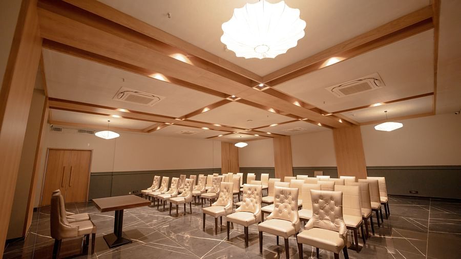 An image of a banquet hall featuring several chairs and a centre table at Pride Resort Ambaji